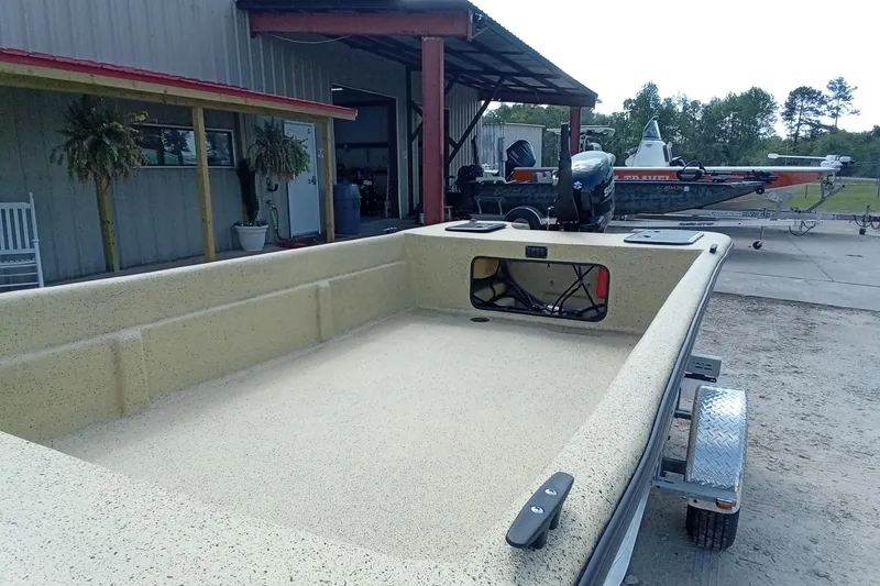 Slide: The Image of 2025 Fibercraft F17 boat on trailer near a metal building. - 5