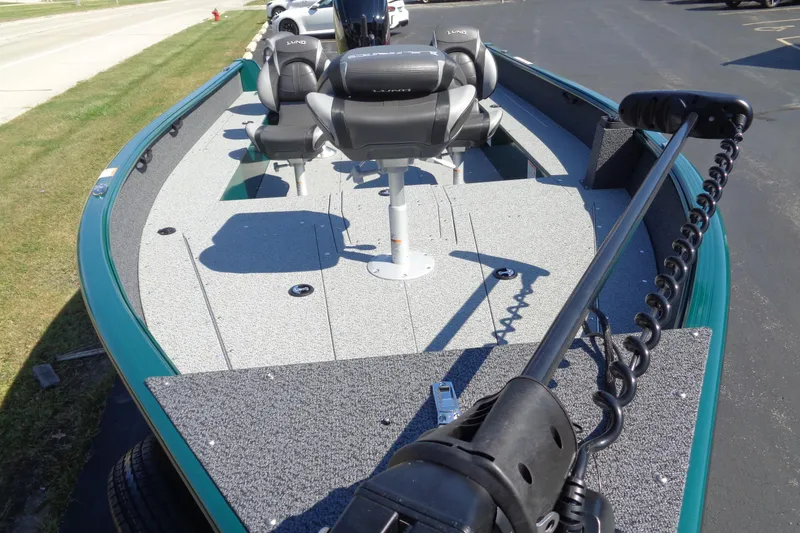 Slide: The Image of 2026 Lund 1800 Explorer Tiller boat with seating and trolling motor on a sunny day. - 14