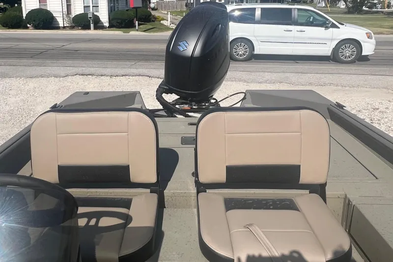 Slide: The Image of 2026 SeaArk V-Cat 200 SC boat interior with seats and motor, parked near a road. - 14