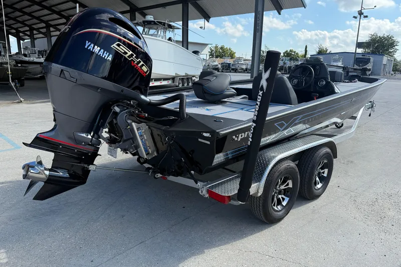 Slide: The Image of 2025 Xpress H20 Bass boat with Yamaha engine on a trailer in a marina. - 6