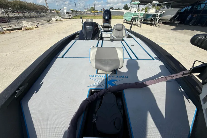 Slide: The Image of 2025 Xpress H20 Bass boat interior with seating and control panel, parked outdoors. - 8