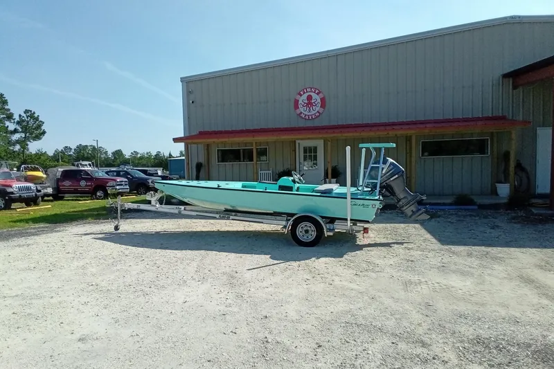 Slide: The Image of 2025 Cast & Blast 17CC Flats boat on trailer outside a marine shop. - 14