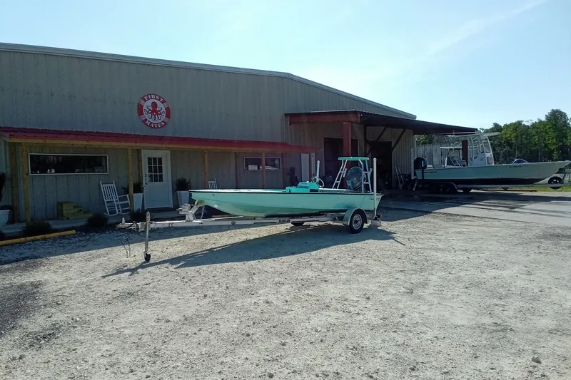 Slide: The Image of 2025 Cast & Blast 17CC Flats boat on trailer outside a metal building. - 3