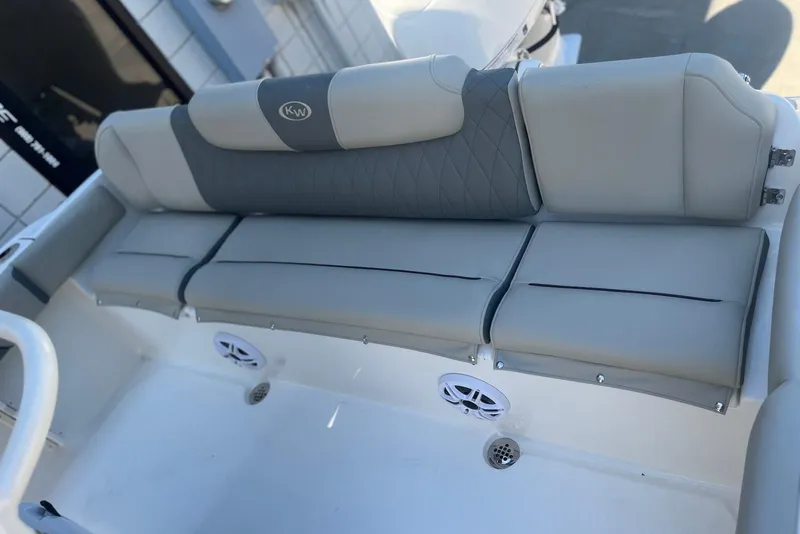 Slide: The Image of 2026 Key West 219 FS boat interior with gray cushioned seating and speakers. - 11