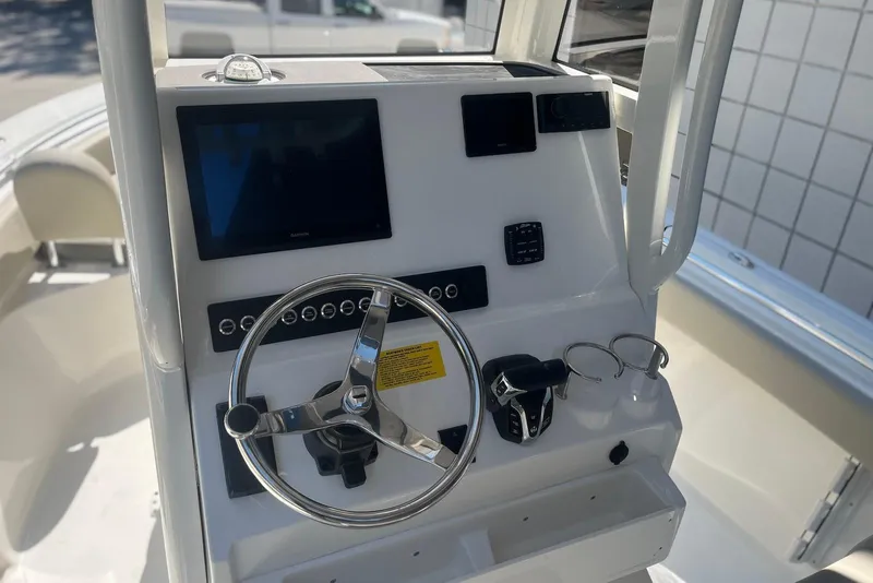Slide: The Image of 2026 Key West 219 FS boat dashboard with steering wheel and navigation controls. - 14