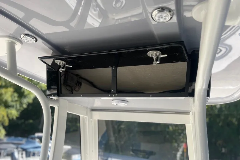 Slide: The Image of 2026 Key West 219 FS boat console storage compartment with secure latches. - 17