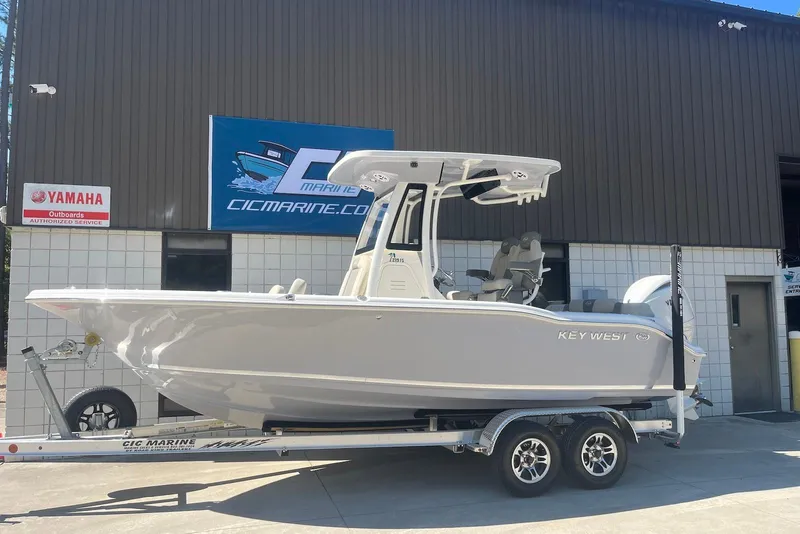 Slide: The Image of 2026 Key West 219 FS boat on trailer outside marine service center. - 2