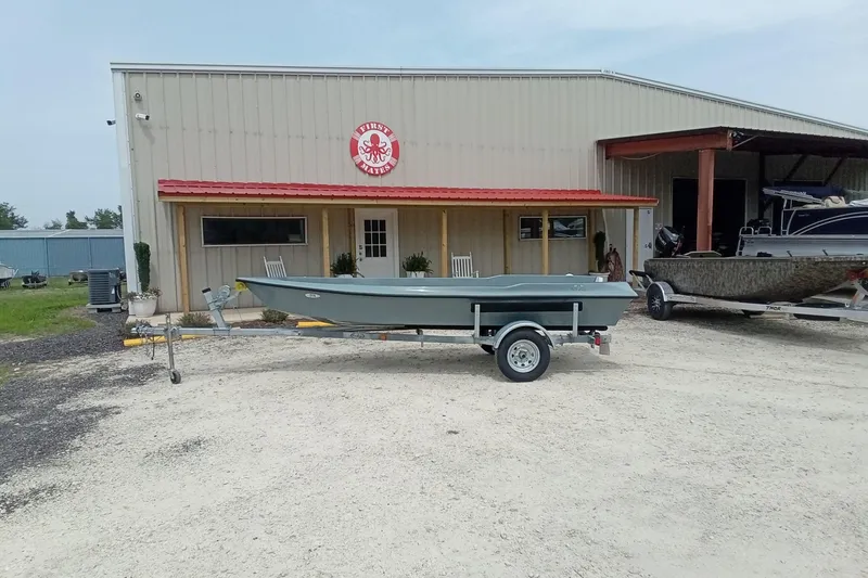 Slide: The Image of Fast Craft XR15 boat on trailer outside a metal building, 2025 model. - 3