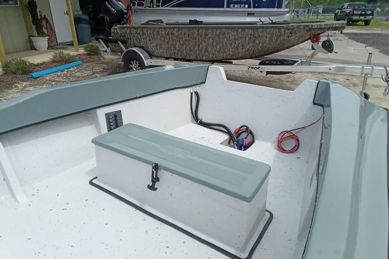 Slide: The Image of 2025 Fast Craft XR15 boat interior with storage compartment and wiring, parked on a trailer. - 6