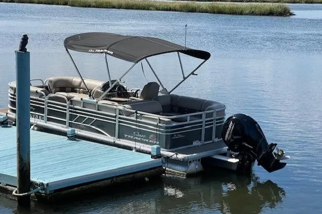 Slide: The Image of 2023 Sun Tracker Party Barge 22 DLX pontoon boat docked on calm water. - 12