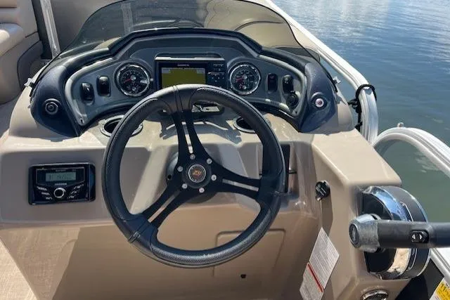 Slide: The Image of 2023 Sun Tracker Party Barge 22 DLX dashboard with steering wheel and controls. - 3