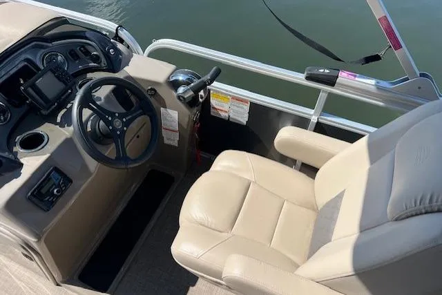 Slide: The Image of 2023 Sun Tracker Party Barge 22 DLX helm with beige captain's chair and steering wheel. - 6