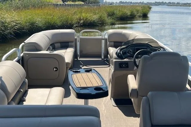 Slide: The Image of 2023 Sun Tracker Party Barge 22 DLX interior with plush seating and steering console. - 7
