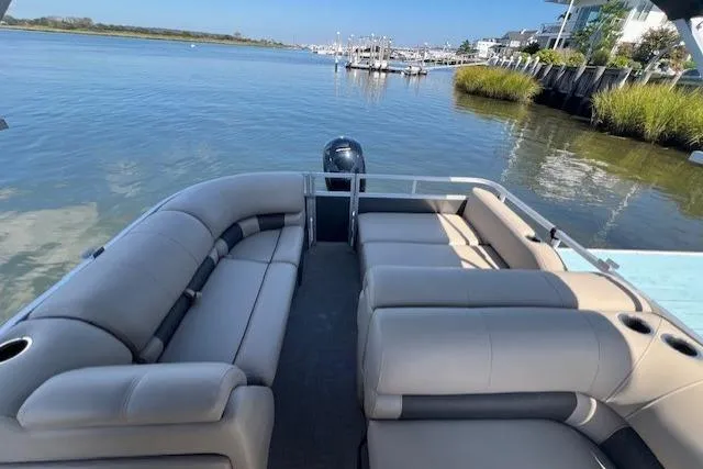 Slide: The Image of 2023 Sun Tracker Party Barge 22 DLX pontoon boat on calm water, featuring spacious seating. - 8
