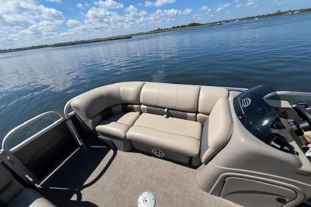 Slide: The Image of 2023 Sun Tracker Party Barge 22 DLX on calm lake with plush seating. - 9