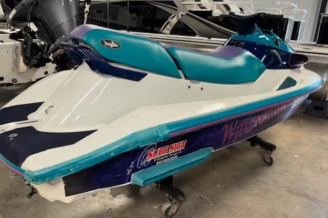 Slide: The Image of 1995 Yamaha WaveRunner Wave Venture jet ski with teal and purple accents in a showroom. - 5