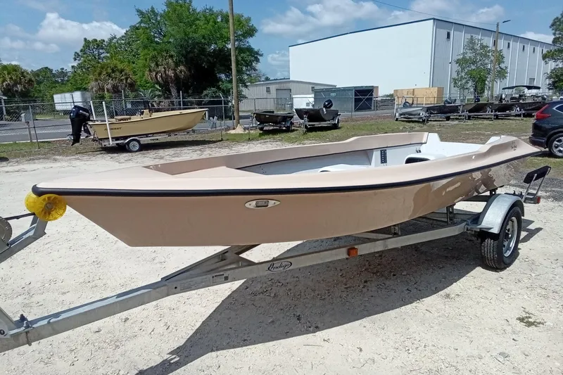 Slide: The Image of 2025 Fast Craft XR15 boat on trailer, parked outdoors near industrial buildings. - 6