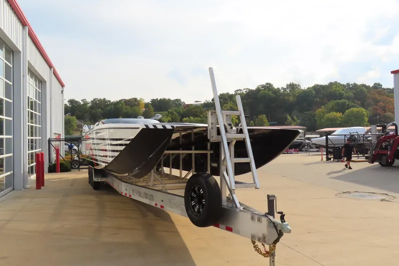Slide: The Image of 2024 MTI 440X powerboat on trailer outside a garage, surrounded by trees. - 4