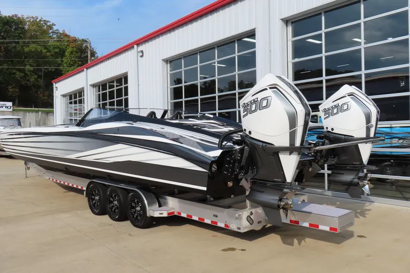 Slide: The Image of 2024 MTI 440X powerboat with dual engines on a trailer outside a garage. - 5