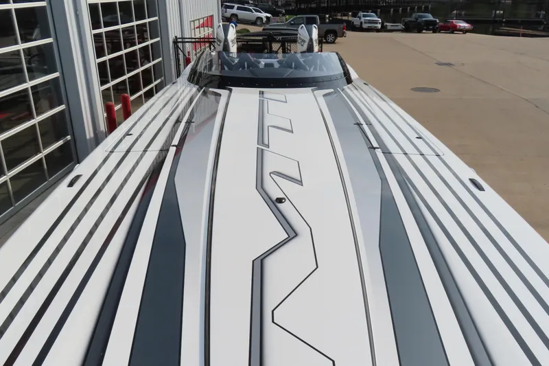 Slide: The Image of 2024 MTI 440X boat with sleek design and modern graphics, parked outdoors. - 8