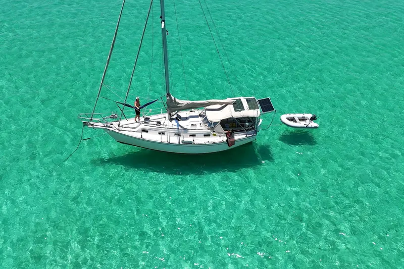 Slide: The Image of Sailboat Island Packet 32 (1995) anchored in clear turquoise water with a dinghy. - 1