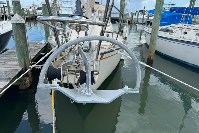 Slide: The Image of 1995 Island Packet 32 sailboat docked, featuring anchor and marina view. - 12