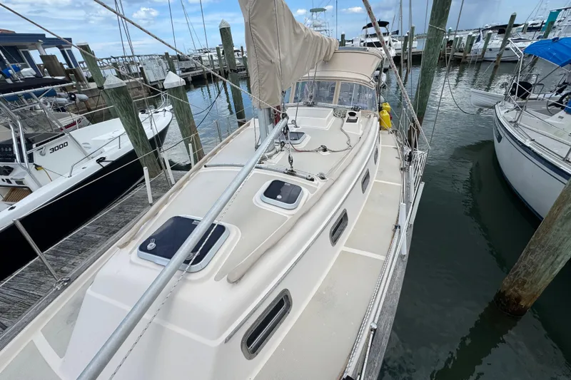 Slide: The Image of 1995 Island Packet 32 sailboat docked at a marina, showcasing deck and rigging. - 14