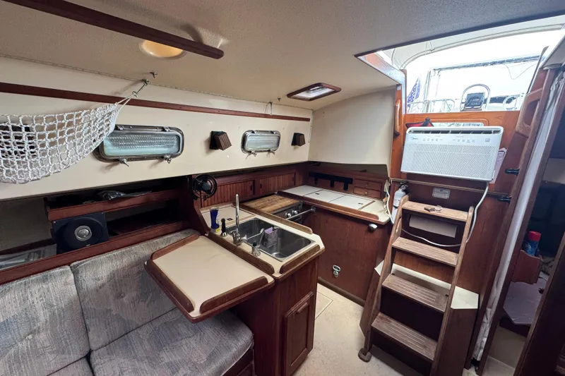 Slide: The Image of Interior of 1995 Island Packet 32 sailboat with kitchen and seating area. - 23