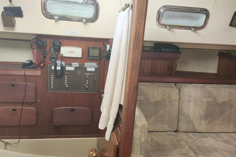 Slide: The Image of Interior of a 1995 Island Packet 32 sailboat, featuring navigation equipment and cozy seating. - 27