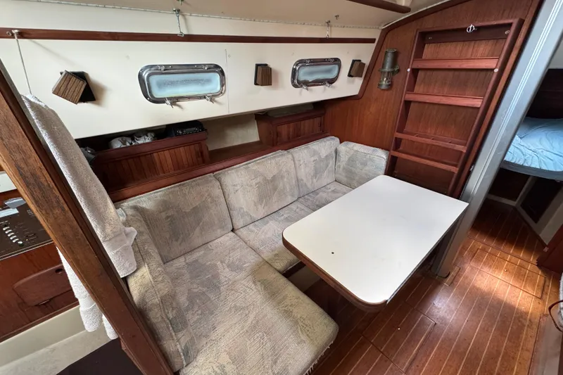 Slide: The Image of Interior of 1995 Island Packet 32 sailboat with cozy seating and wooden accents. - 31