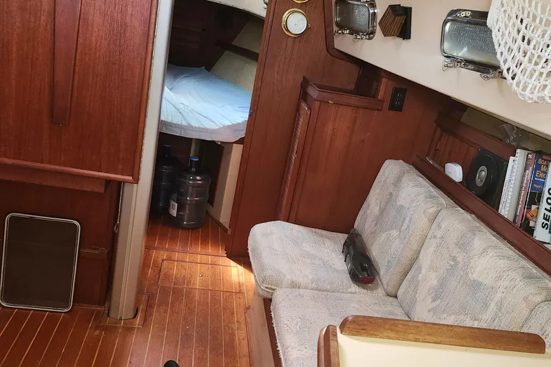 Slide: The Image of Interior of 1995 Island Packet 32 sailboat with cozy seating and wooden finishes. - 34