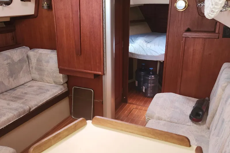 Slide: The Image of Interior of 1995 Island Packet 32 sailboat with cozy seating and wooden finishes. - 35