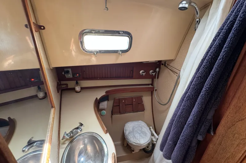 Slide: The Image of 1995 Island Packet 32 sailboat bathroom with sink, toilet, and shower. - 38