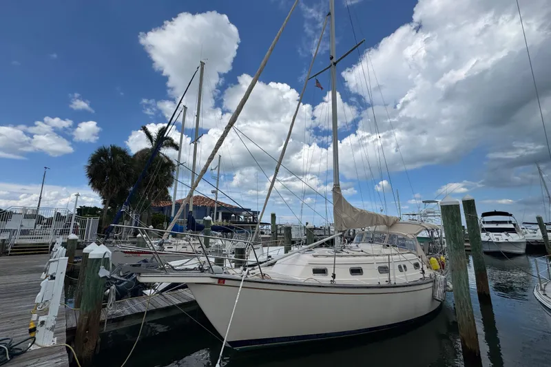 Slide: The Image of 1995 Island Packet 32 sailboat docked at marina under blue sky with clouds. - 4