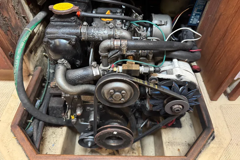 Slide: The Image of Engine compartment of a 1995 Island Packet 32 sailboat, showing detailed mechanical components. - 40