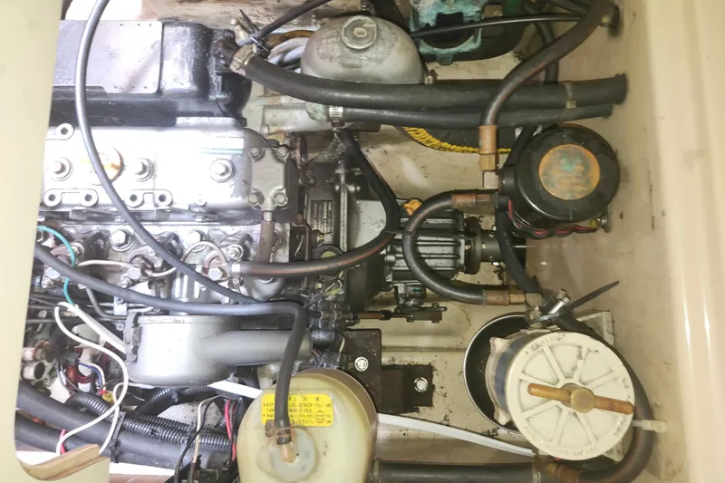 Slide: The Image of Engine compartment of a 1995 Island Packet 32 sailboat, showing mechanical components and hoses. - 42