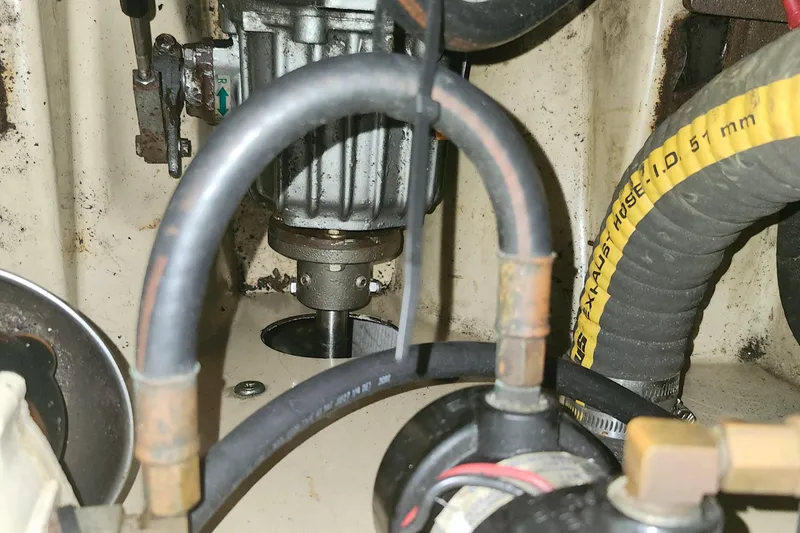 Slide: The Image of Engine compartment of a 1995 Island Packet 32 sailboat, showing hoses and mechanical components. - 44