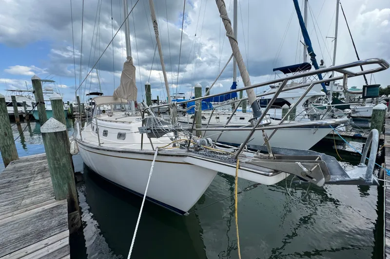 Slide: The Image of 1995 Island Packet 32 sailboat docked at marina under cloudy sky. - 5