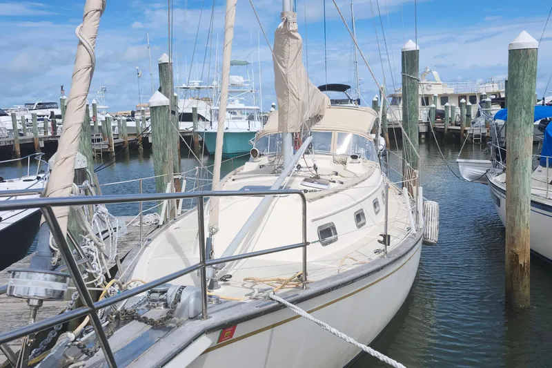Slide: The Image of 1995 Island Packet 32 sailboat docked at a marina under a clear blue sky. - 6