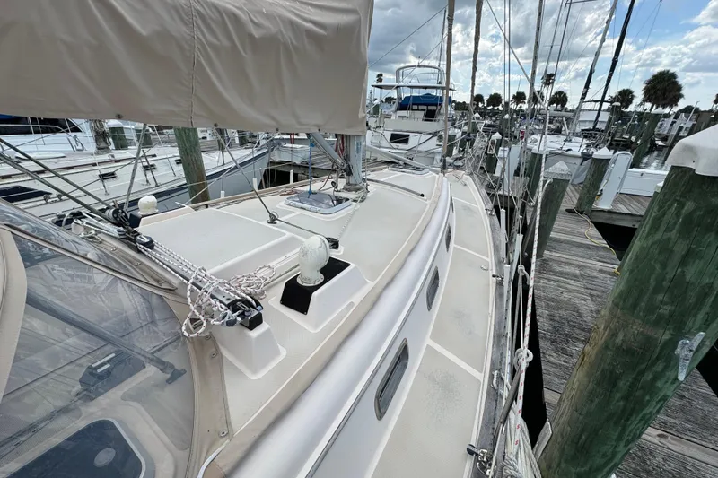 Slide: The Image of 1995 Island Packet 32 sailboat docked at marina, showcasing deck and rigging. - 9