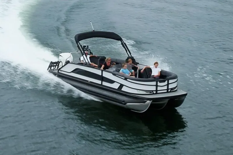 Slide: The Image of Evotti 521CS 2026 pontoon boat cruising on water with passengers enjoying the ride. - 12