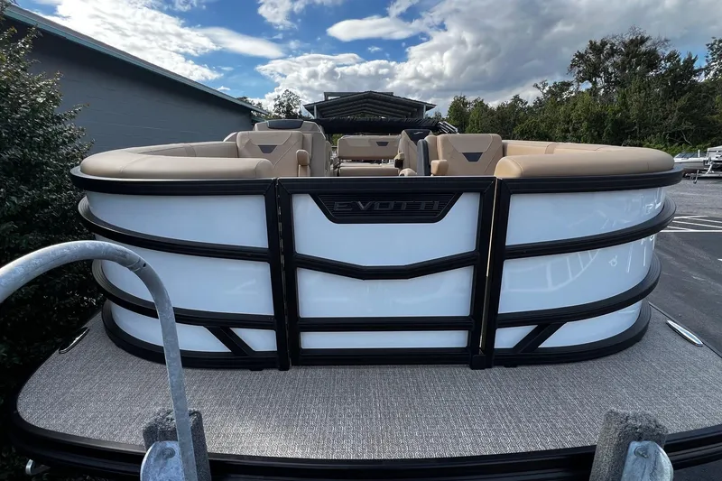 Slide: The Image of 2026 Evotti 521CS pontoon boat with beige seating, parked outdoors under a cloudy sky. - 5