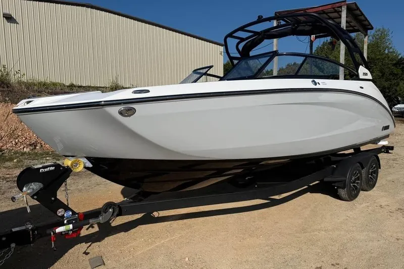 Slide: The Image of 2026 Yamaha Boats 252S on trailer, sleek white design, parked outdoors. - 1