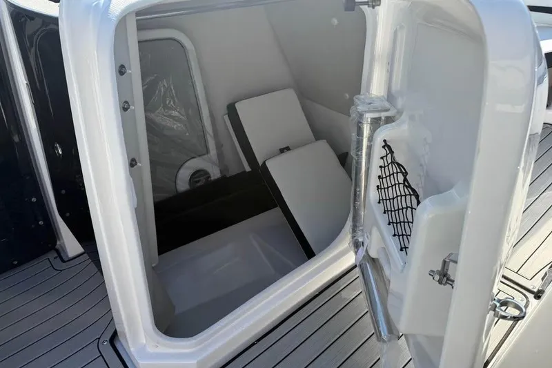 Slide: The Image of 2026 Yamaha Boats 252S storage compartment with open door and interior view. - 12