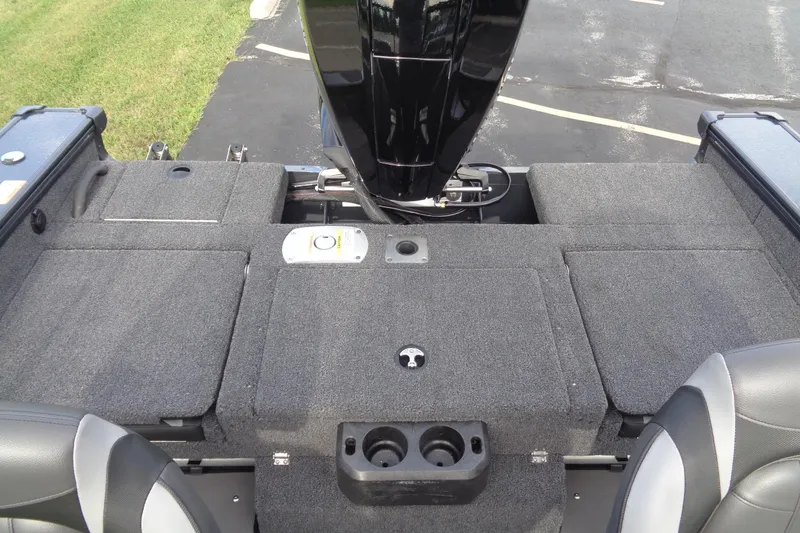 Slide: The Image of 2026 Lund 1875 Crossover XS boat interior with gray carpet and motor view. - 12