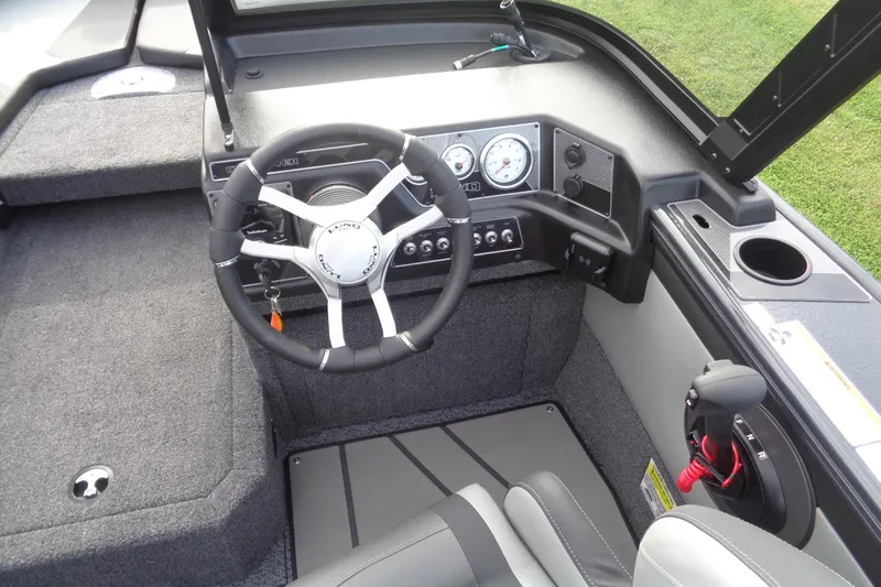 Slide: The Image of 2026 Lund 1875 Crossover XS boat cockpit with steering wheel and control panel. - 16