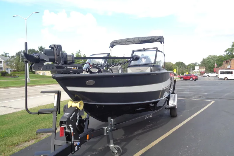Slide: The Image of 2026 Lund 1875 Crossover XS boat on trailer, parked in a lot, front view. - 9
