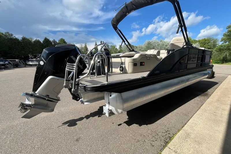 Slide: The Image of 2020 Barletta L23U pontoon boat with Mercury outboard motor, parked on a sunny day. - 3