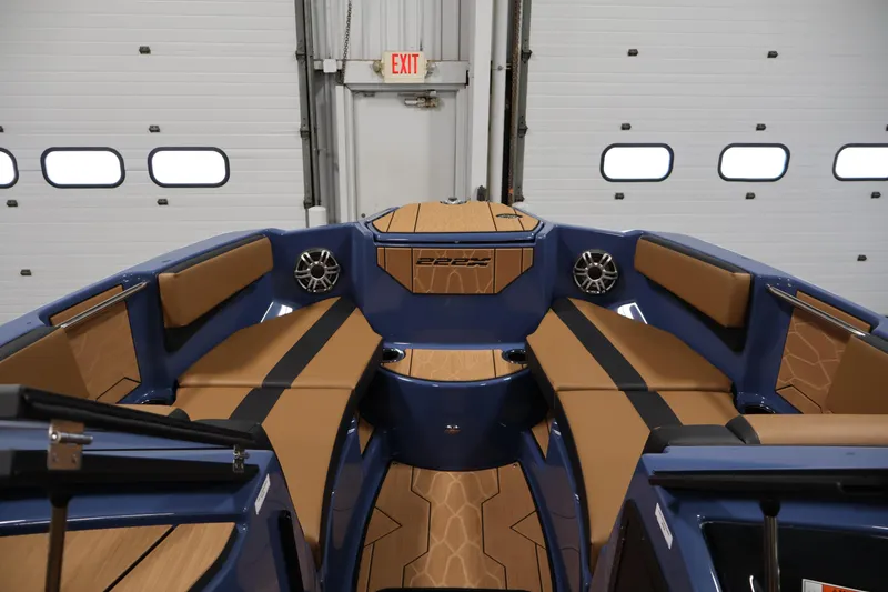 Slide: The Image of 2026 Yamaha Boats 222XD interior with tan seating and blue accents in a garage setting. - 10