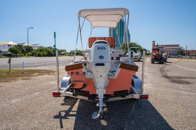 Slide: The Image of 2025 Caribiana Maracas 23 Skiff on trailer, parked outdoors under clear blue sky. - 10